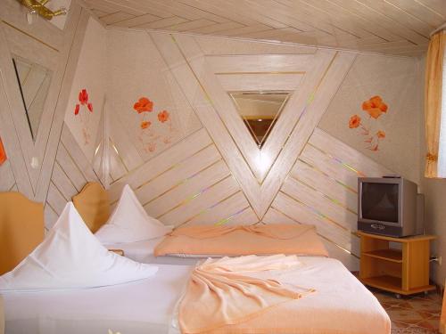 a bedroom with two beds and a tv at Central Hotel in Schwetzingen