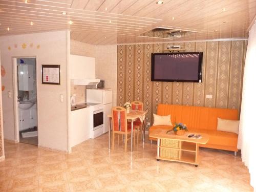 a living room with an orange couch and a table at Central Hotel in Schwetzingen