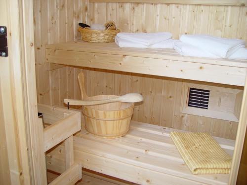 a wooden sauna with two wooden shelves and a bucket at Central Hotel in Schwetzingen