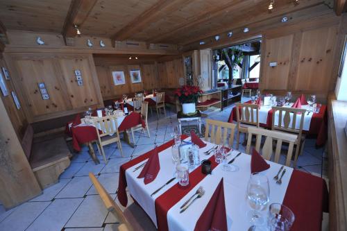 a restaurant with tables and chairs with red napkins at Crusch Alba in Scuol