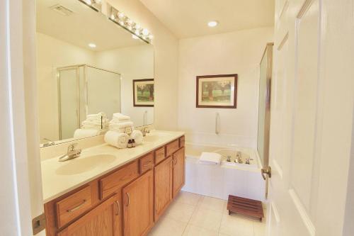 a bathroom with a sink and a mirror and a tub at Treasure Coast Getaway in Carlton