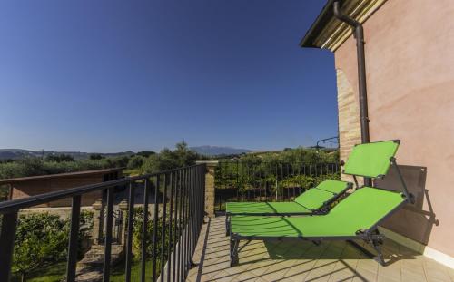 a green chair sitting on the balcony of a house at Appartamento Mimosa in Ripa Teatina