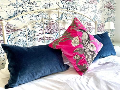 a pink pillow sitting on top of a bed with pillows at Findon Manor Hotel in Worthing