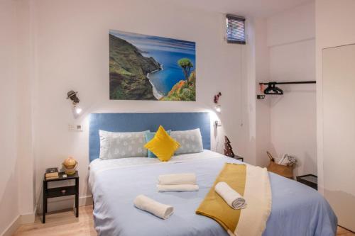 Un dormitorio con una cama azul y blanca con toallas. en La Candela en Santa Cruz de la Palma