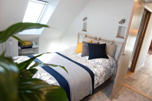 um quarto com uma cama com almofadas azuis e laranja em The Roost - a bird's eye view in the countryside em Cullompton