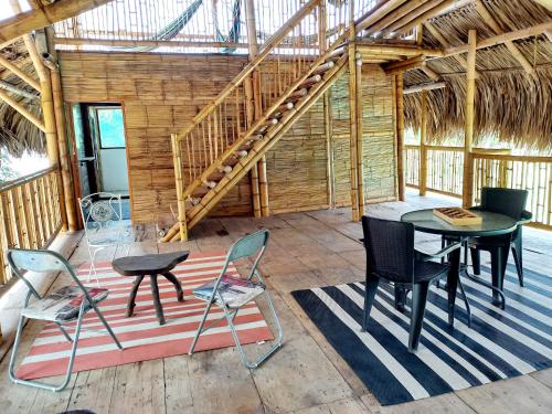 ein Zimmer mit einem Tisch, Stühlen und einer Treppe in der Unterkunft Casa Estuario in Buritaca