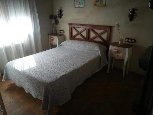 een slaapkamer met een bed en een raam bij casa rural La picotina in Navaconcejo