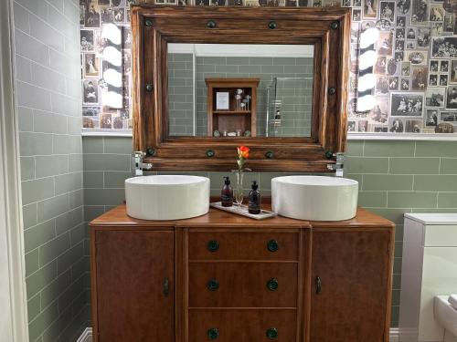 a bathroom with two sinks on a wooden dresser with a mirror at Atholl Arms Hotel Dunkeld in Dunkeld