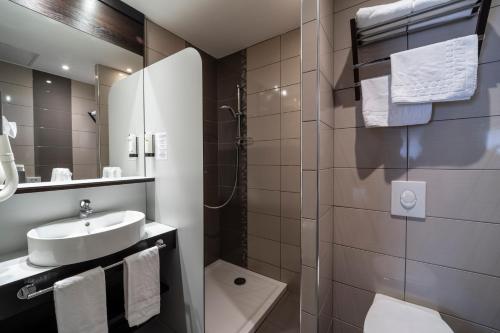 une salle de bain avec un lavabo, des toilettes et une douche dans l'établissement Logis Cottage Hotel, à Vandœuvre-lès-Nancy