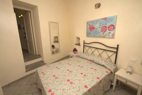 a bedroom with a bed with a floral bedspread at Appartamenti Chiarina in Dolcedo
