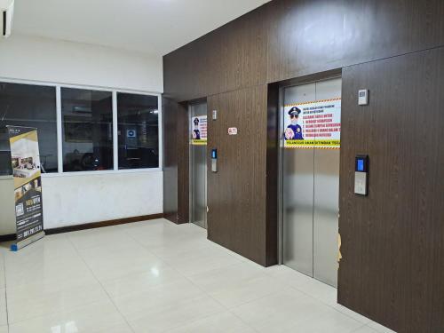 een hal met twee liften in een gebouw bij Paradise Room By Vivo Apartment in Seturan
