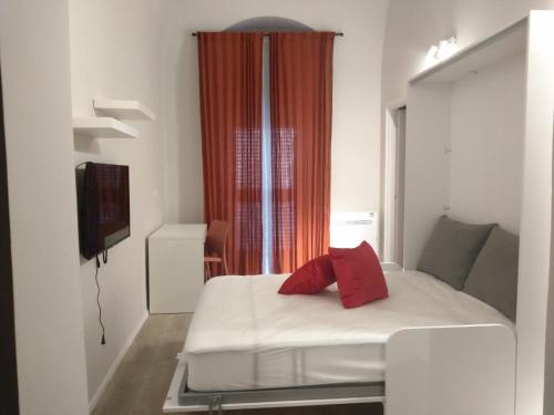 una camera da letto con un letto con cuscini rossi di Paoli 28 Holiday Homes a Corato