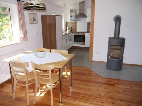 a kitchen and dining room with a table and a stove at Ferienwohnung Albert in Kirchzell