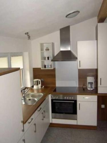 a kitchen with a sink and a stove top oven at Ferienwohnung Albert in Kirchzell