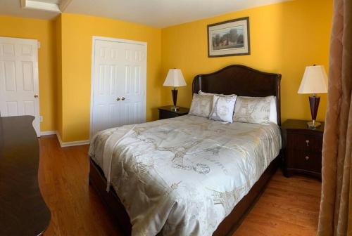 um quarto com uma cama grande e paredes amarelas em The Best Vacation Home To Fit All Your Needs! em Hyattsville