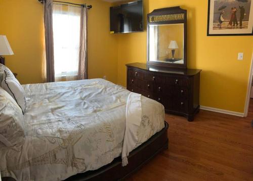 a bedroom with a bed and a dresser and a mirror at The Best Vacation Home To Fit All Your Needs! in Hyattsville