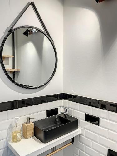 une salle de bain avec un lavabo noir et un miroir dans l'établissement Magnifique vue sur les montagnes au cœur de Luchon 6-8 pers, à Luchon