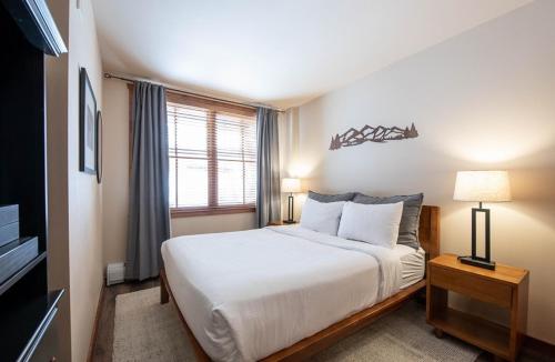 een slaapkamer met een groot wit bed en een raam bij Secluded Condo with Corridor Ski Trail View - Zephyr Mountain Lodge Premium Unit 1201 condo in Winter Park
