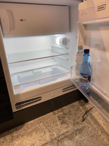 an open refrigerator with two bottles of water in it at Wileńska Home apartment 1 in Warsaw