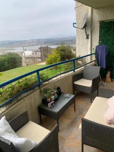 a balcony with chairs and tables and a view of the water at Departamento con vista al mar concon in Concón