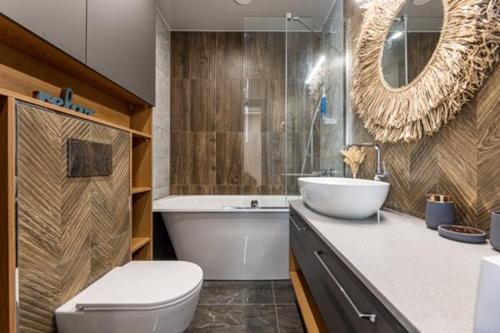 a bathroom with a toilet and a sink and a tub at Pajūrio Oazė MG13 in Klaipėda