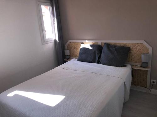 une chambre avec un grand lit blanc avec une fenêtre dans l'établissement Charmant pavillon T2 avec terrasse et parking privé, près commerces et plage privée au Barcarès - FR-1-81-259, au Barcarès