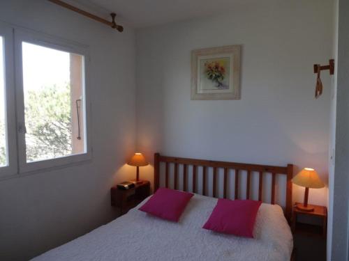 - une chambre avec un lit doté de 2 oreillers violets dans l'établissement Bel appartement 4 personnes avec piscine, parking privé et vue marina - FR-1-81-238, au Barcarès