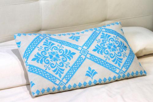 uma almofada azul e branca sentada numa cama em ### Appartamenti sulla SPIAGGIA al POETTO ### em Cagliari