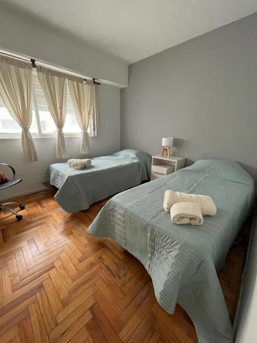 1 dormitorio con 2 camas y suelo de madera en Kuky's home en Buenos Aires