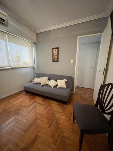 sala de estar con sofá y ventana en Kuky's home en Buenos Aires