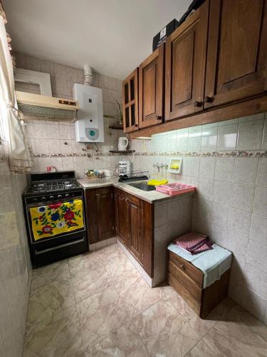 cocina pequeña con armarios de madera y fogones en Kuky's home en Buenos Aires