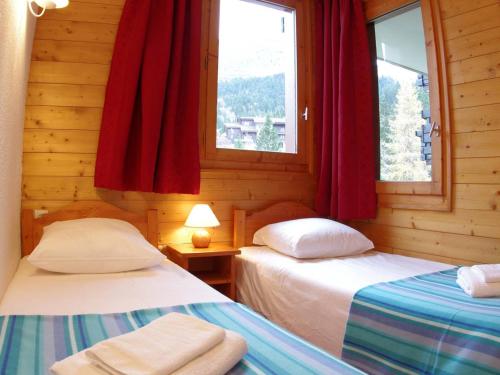 two beds in a room with two windows at Appartement Valmorel, 3 pièces, 6 personnes - FR-1-291-765 in Valmorel