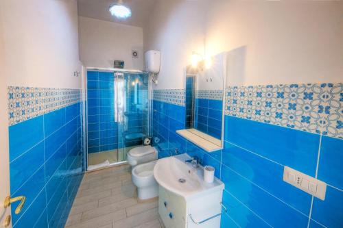 カリアリにある### Appartamenti sulla SPIAGGIA al POETTO ###の青いバスルーム(トイレ2つ、シンク付)