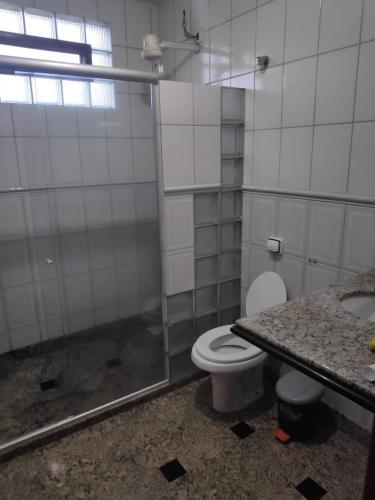 a bathroom with a toilet and a shower and a sink at Casa de Temporada Meaipe in Guarapari