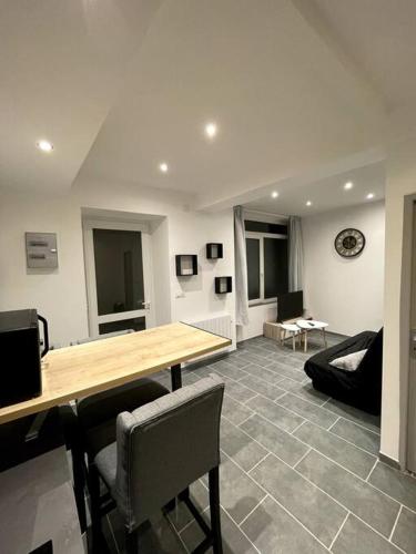 un salon avec une table et des chaises en bois dans l'établissement Jolie T2 au coeur des collines, à Les Veyrières