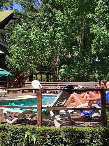 un grupo de personas sobre tumbonas junto a una piscina en Alpenhaus Bier und Gasthaus en Tigre
