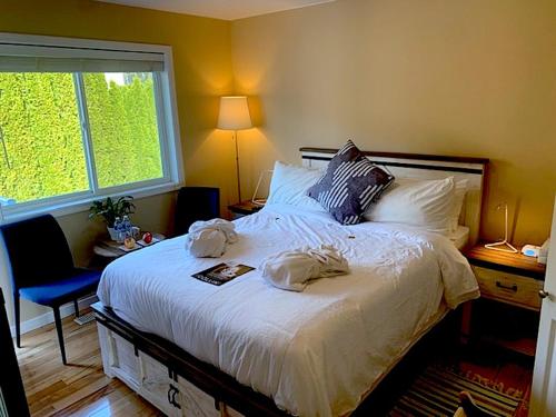 a bedroom with a large bed with two towels on it at Salish B&B and Spa in West Kelowna