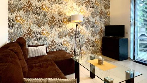 a living room with a couch and a table at Apartamenty Villa Fiori - Wyspa Sobieszewska in Gdańsk