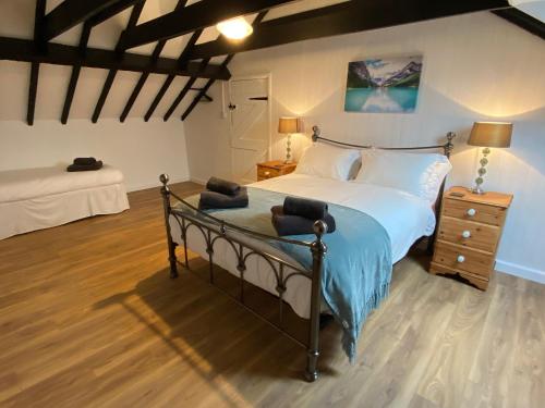 sypialnia z dużym łóżkiem i drewnianą podłogą w obiekcie Pembrokeshire Near The Beach With A Heated Pool w mieście Pembroke