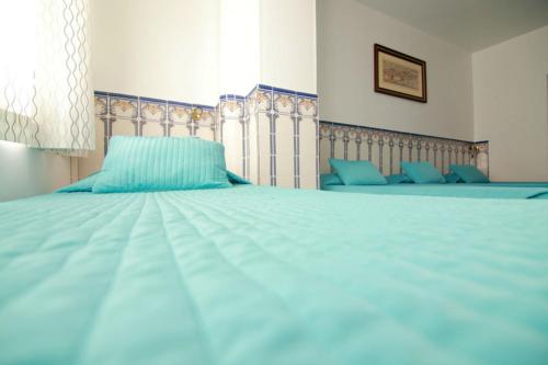 a bed with a blue blanket and blue pillows at Residencial Joao XXI in Lisbon