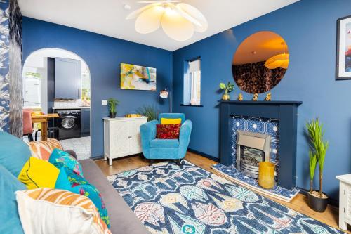 Whiteoak House في بولتون: غرفة معيشة مع جدران زرقاء ومدفأة