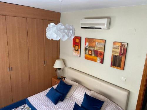 ein Schlafzimmer mit einem Bett mit blauen Kissen in der Unterkunft Real Torrequebrada in Benalmádena