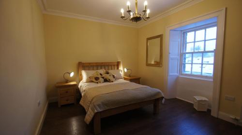 Schlafzimmer mit einem Bett und einem Fenster in der Unterkunft Comrie Old Schoolhouse in Comrie