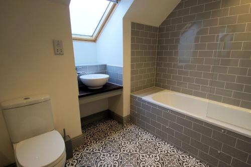 a bathroom with a toilet and a sink and a tub at Comrie Old Schoolhouse in Comrie