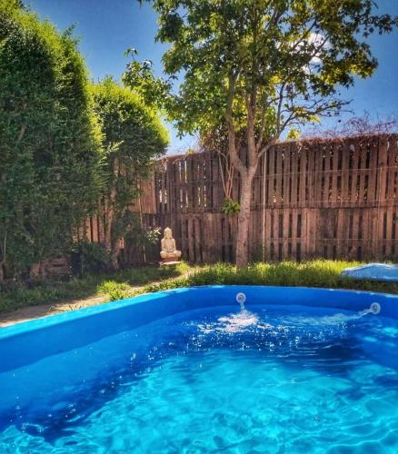 una piscina azul en un patio con una valla de madera en Casa con pileta - El PATIO DE BUDA en San Pedro