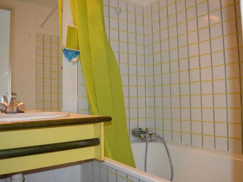 a bathroom with a green shower curtain next to a sink at Appartement Argelès-sur-Mer, 3 pièces, 6 personnes - FR-1-225-453 in Argelès-sur-Mer
