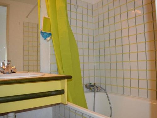 La salle de bains est pourvue d'un rideau de douche vert à côté d'un lavabo. dans l'établissement Appartement cosy au Port d'Argelès, 2 pièces/cabine, 6 couchages, proche mer, loggia, ménage inclus - FR-1-225-453, à Argelès-sur-Mer