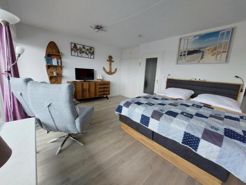 ein Schlafzimmer mit einem Bett, einem Stuhl und einem Schreibtisch in der Unterkunft SPO - gemütliches Apartment - TOP LAGE in Sankt Peter-Ording