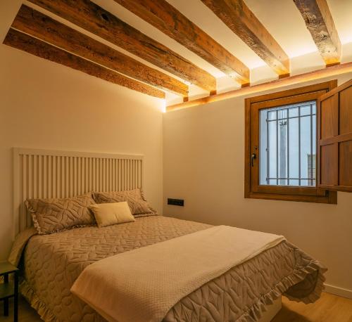 1 dormitorio con cama y ventana en El Clavel de la Plaza, en Cuenca