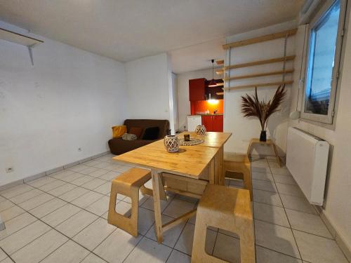 a living room with a wooden table and chairs at T2 Parc & Cité Internationale in Caluire-et-Cuire